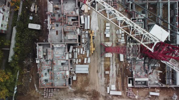Aerial footage top-down view of the crane and buildings under construction.