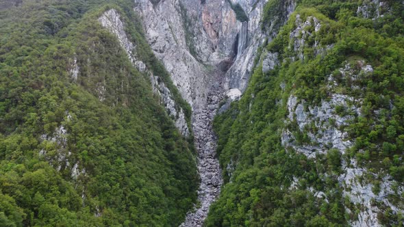 Aerial shot of a canyon with a huge waterfall in Slovenia.