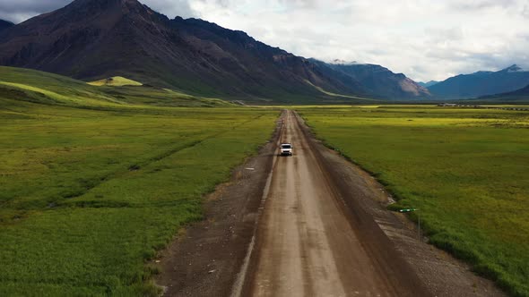Road trip on a van through Portage valley by the Brooks Range mountains in Summer Alaska - Aerial tr alt