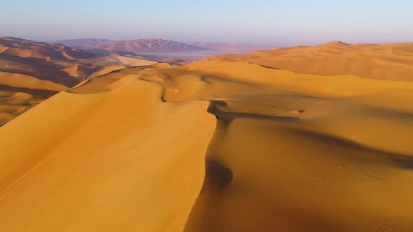 Aerial view of a man sitting on the edge of dunes, U.A.E. alt