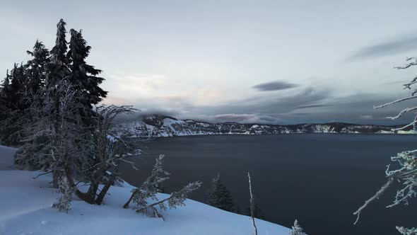 Aerial video of snowy shore of Crater Lake, Oregon, USA, drone footage of lake alt