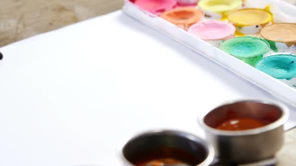 Watercolor paint and paintbrushes with canvas alt