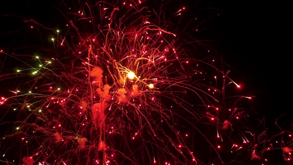 Red Green and Gold Sparks of Fireworks Scatter Across Black Sky Slow Motion alt
