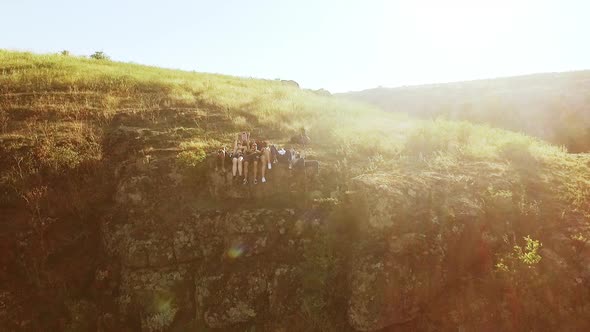 Friends Lying Sitting on Rocky Cliff Waving Hands Talking Smiling in Slowmotion alt