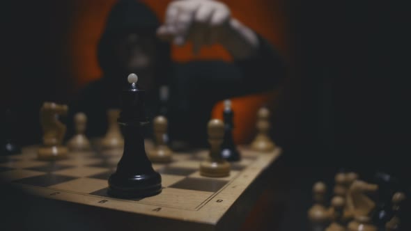 Hand Moving Black Queen Piece Defeating White King on Chessboard Man Playing Chess Game.  alt