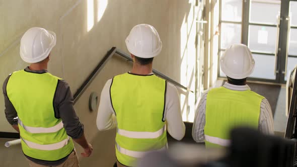 Architects in Helmets Walking Downstairs at Office alt