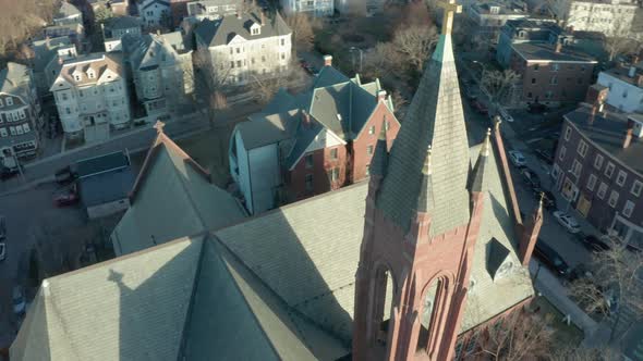 Aerial Drone Shot Orbiting a Brick Church Steeple Before Tilting Up