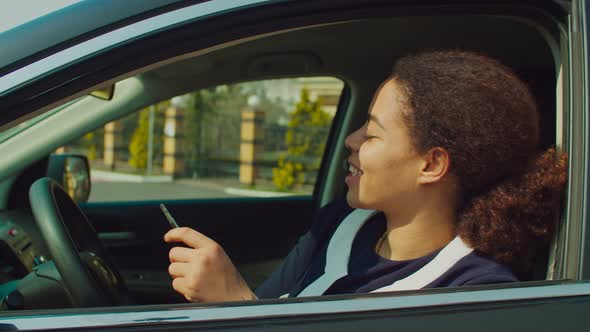 Proud Woman New Car Owner Sitting in Driver's Seat alt