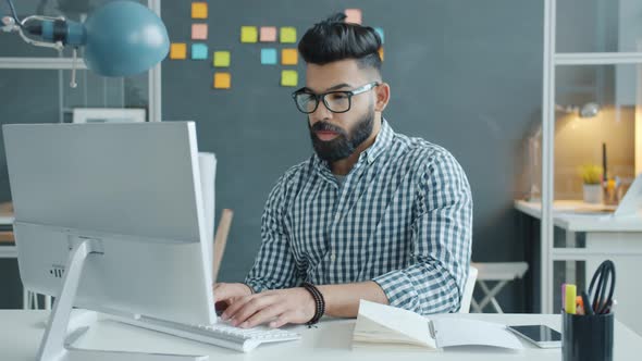 Mixed Race Guy Suffering From Headache Touching Head Working with Computer in Office alt