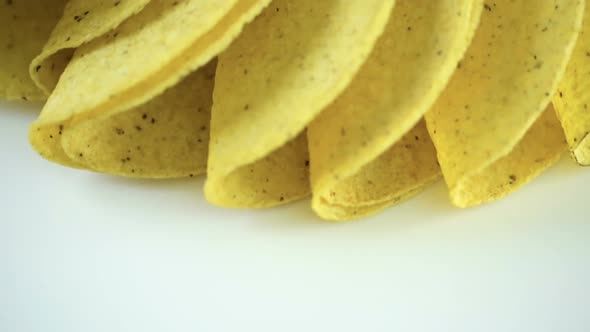 Yellow corn taco shells on a white background. alt
