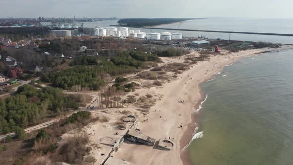 AERIAL: Melnrage Beach with Klaipeda City and Ship Port Visible in a Distance on a Cloudy Day