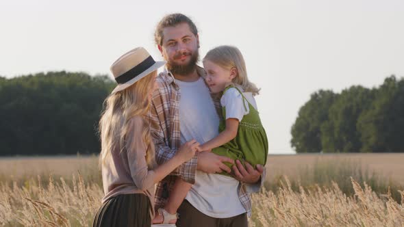 Happy Caucasian Family Farmers Young Parents with Little Daughter Girl Child Stand Outdoors in Wheat alt