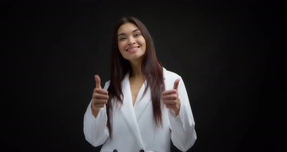 Positive Woman Smiles at the Camera and Gives Two a Thumbs Up