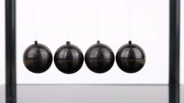 Macro shot, Newton's Cradle metal balls on wooden desk
