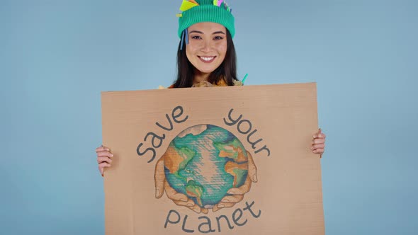 Woman holding cardboard with inscription save your planet on it.