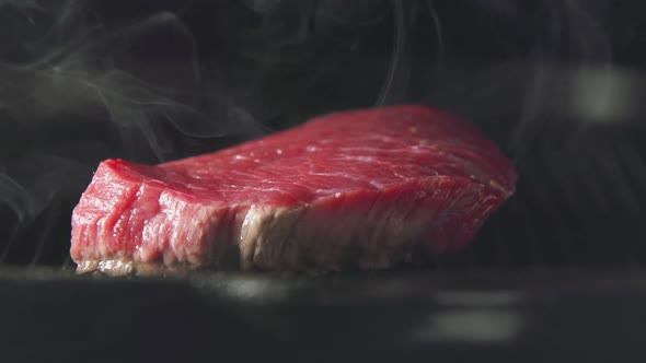 Steak Of Meat Is Cooking On A Grill