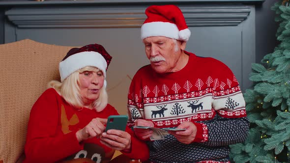 Happy Senior Family on Mobile Phone Buy Christmas Presents Doing Online Ecommerce Shopping Purchase alt