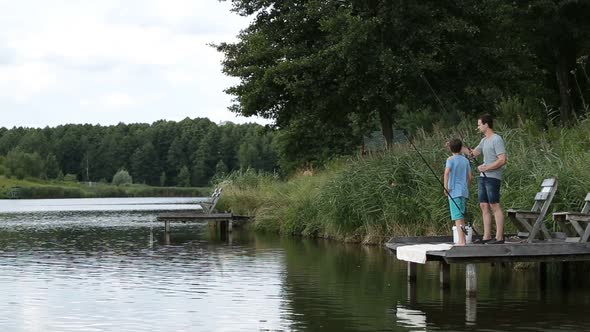 Relaxed Father and Son Fishing at Freshwater Pond alt
