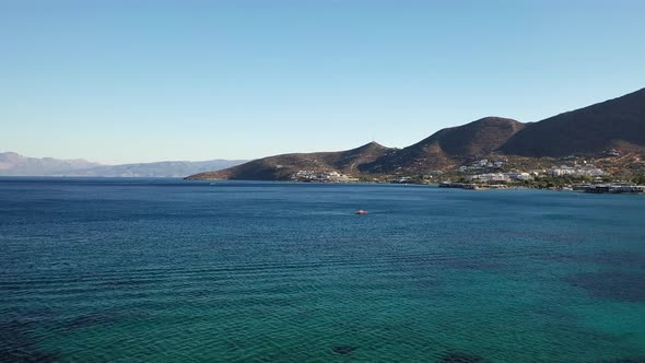 Aerial View of a Speeding Motor Boat in a Deep Blue Colored Sea. Spinalonga Island, Crete, Greece