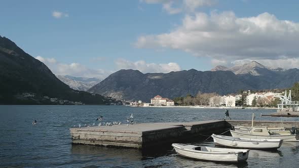 Motor boats on the shore on the background of the mountains in Montenegro in winter alt