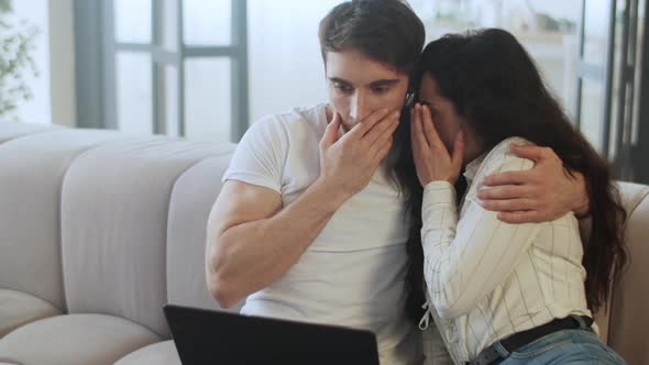 Closeup Scared Couple Watching Laptop Computer at Home in Slow Motion. alt