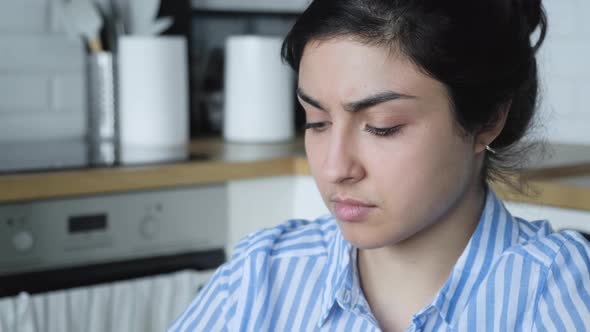 Close up of a Serious Young Indian girl in a blue striped shirt working on a computer alt