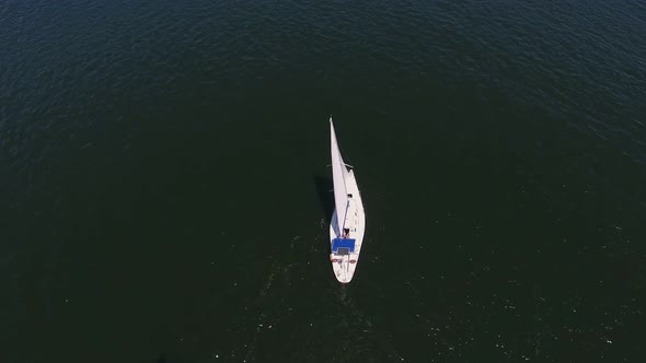 Aerial Shot of a Small Yacht Sailing in the Dnipro on a Sunny Day in Summer  