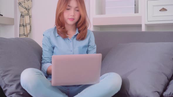 Asian woman working on laptop in living room,  beautiful female feeling tired sleeping after work. alt