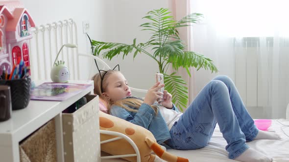 a Little Girl with a Phone in Bed alt