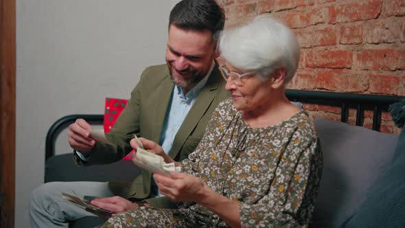 European Pensioner Mother Laughs Out Loud While Looking at Old Photographs and Celebrating Mother's alt