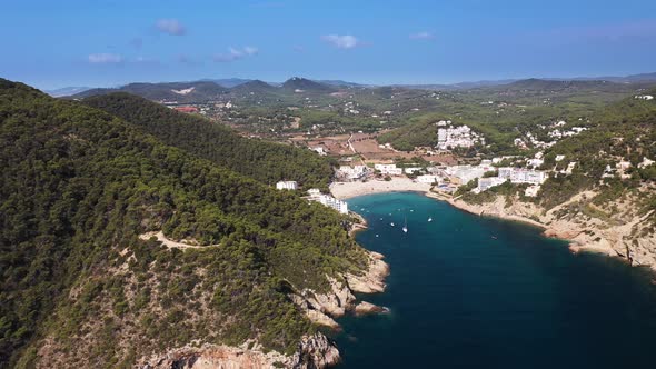 Aerial footage of the Spanish island of Ibiza showing the beautiful beach front alt