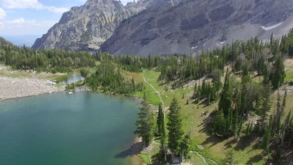 Camera tracks forward towards a crossroad with hikers in the distance alt