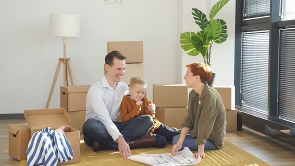 Relaxed Family With Child Boy Sit On Floor Talking Planning Their Home Interior Moving Into New
