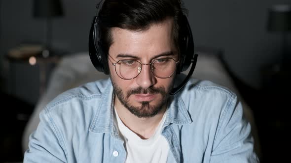 Close-up of a Young Man Thinking Looking at a Computer, Using a Laptop Working Online alt
