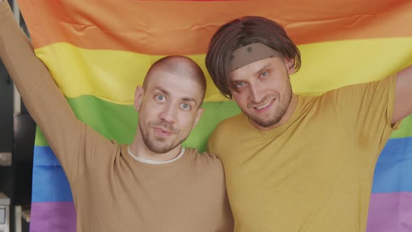 Gay Men with Rainbow Flag Posing for Camera alt