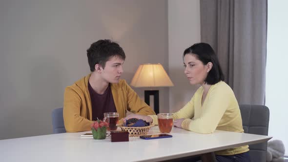 Middle Shot of Anxious Caucasian Brunette Woman Telling Bad News To Teenage Boy, Mother Sharing alt