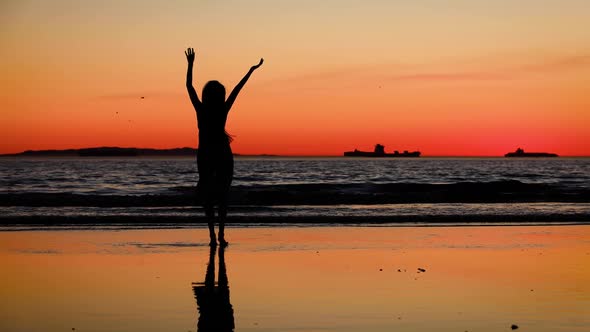Asian woman enjoys a walk on the beach at sunset. Slow Motion. alt