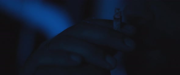 Close up of a man smoking a cigarette outside at night, dealing with anxiety and post trauma alt