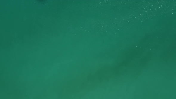 An aerial progression from shallow clear water to deep green water creating a sense of adventure and alt