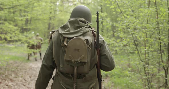 American Soldier Of USA Infantry Of World War II Marching Walking Along Forest Road In Summer Day alt