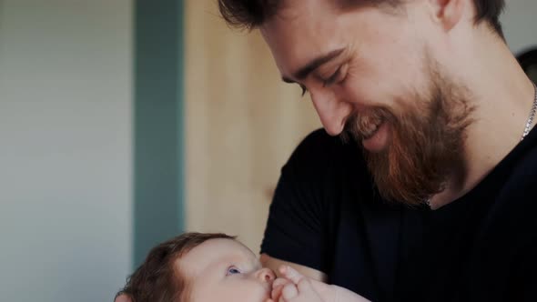 True Face Emotions of Happy Bearded Father with His Little Infant alt