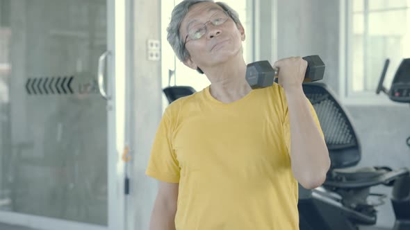Elderly man sitting lifting dumbbell for training arms strengthen muscle doing activities retired. alt
