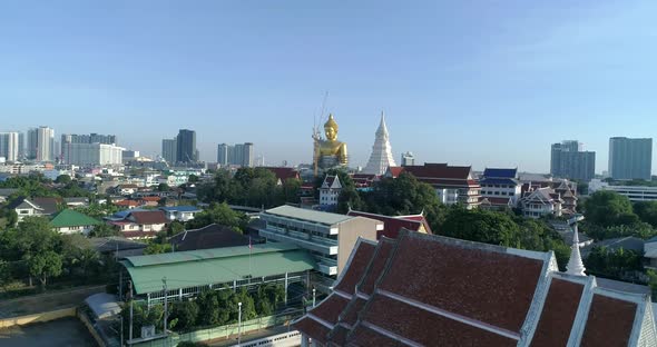 Big Golden Buddha sitting in a city landscape, Wat Paknam under construction. DRONE AERIAL alt