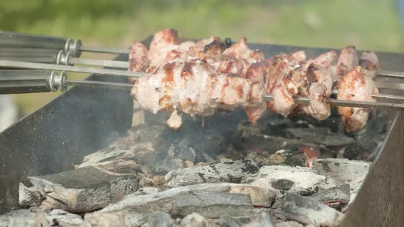 Kebab is Sprayed with Water on a Barbecue Grill Over Charcoal