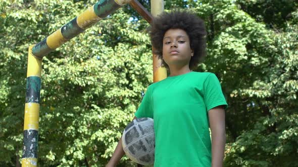 Black Male Teenager Looking Camera Holding Football, Sport Training Outdoor