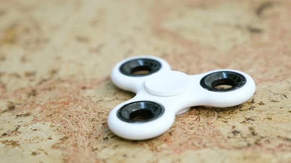 White Hand Spinner To Spin on a Wooden Table