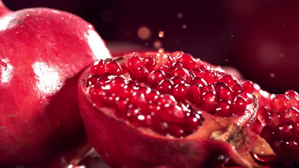 Slow Motion Shot of Pomegranate Juice Splashing Through Pomegranate alt
