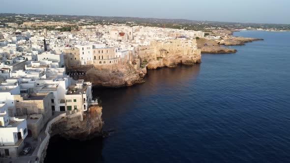 Houses and cliffs of the beautiful coastal town of Polignano a Mare, drone alt