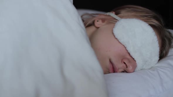 Young woman sleep on comfortable bed in a mask for sleeping
