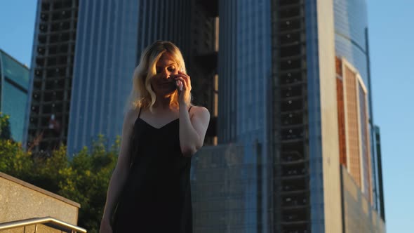 stylish woman talking on the phone on the background of skyscrapers